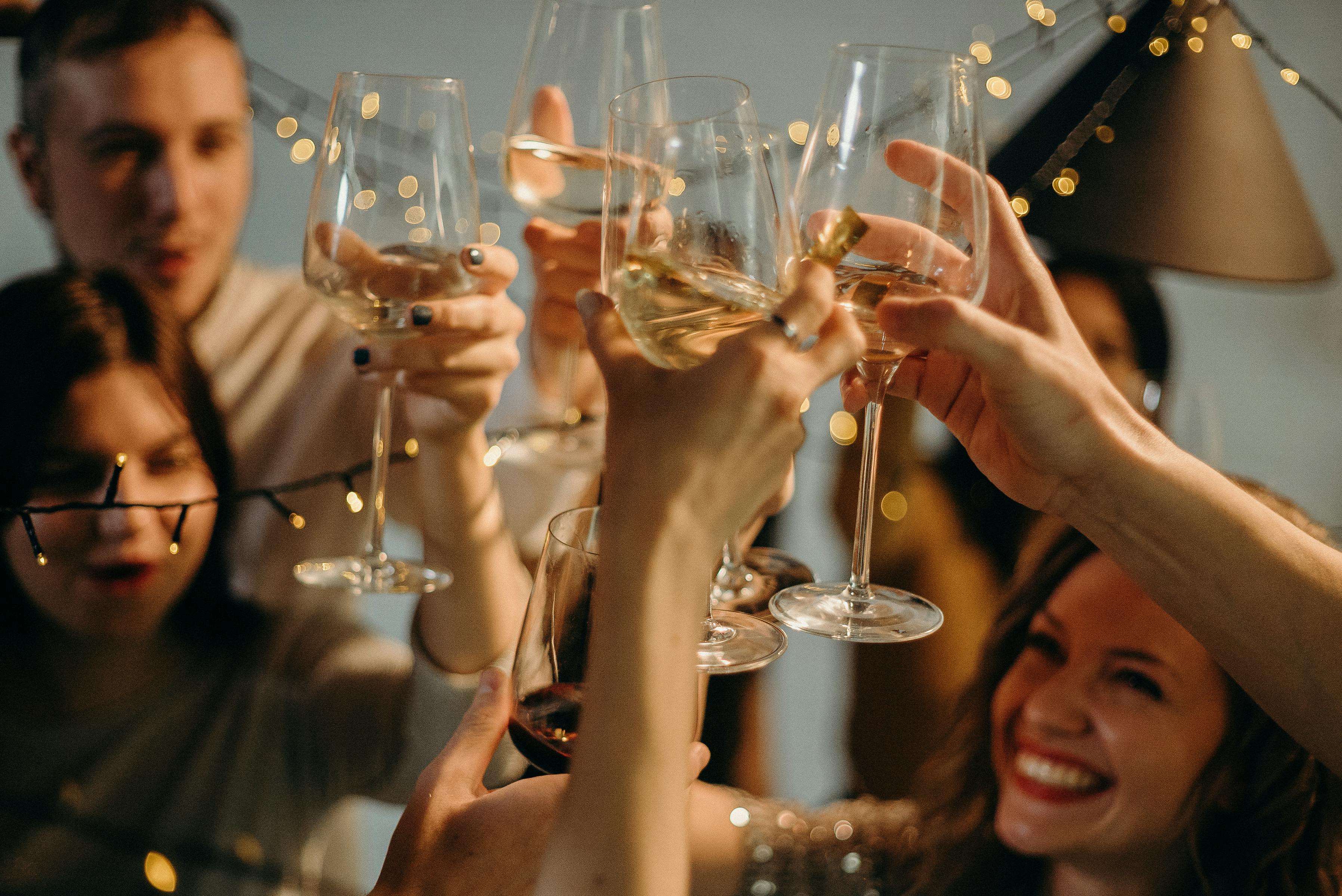 people raising wine glasses at a Christmas party