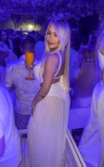 Nina wearing a white dress at a party 